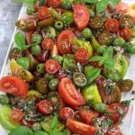 Overhead photo of Heirloom Tomato Salad on a rectangle platter.