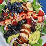 Overhead photo of a platter of Chicken Berry Salad with avocado and almond slivers.