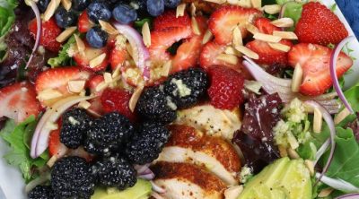 Overhead photo of a platter of Chicken Berry Salad with avocado and almond slivers.