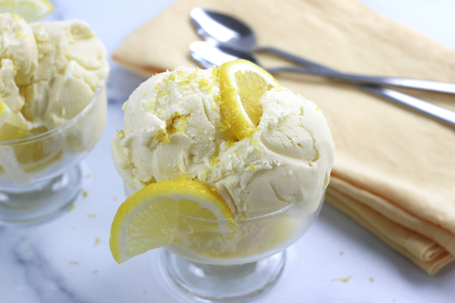 2 servings of Lemon Chiffon Ice Cream sitting on a white marble countertop.