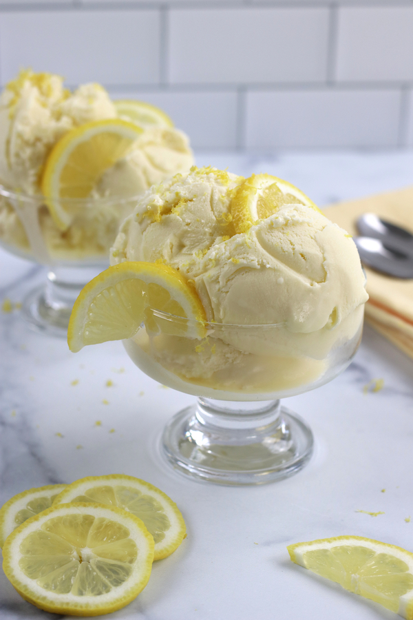 Two glass ice cream dishes with Limoncello Ice Cream sitting on a marble countertop.
