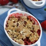 Strawberry Crumble in a white ramekin sitting on a blue napkin.