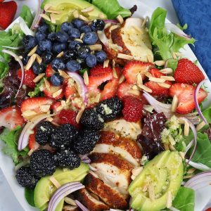 A larger plate of Summer Chicken Salad with blueberries, blackberries and strawberries.