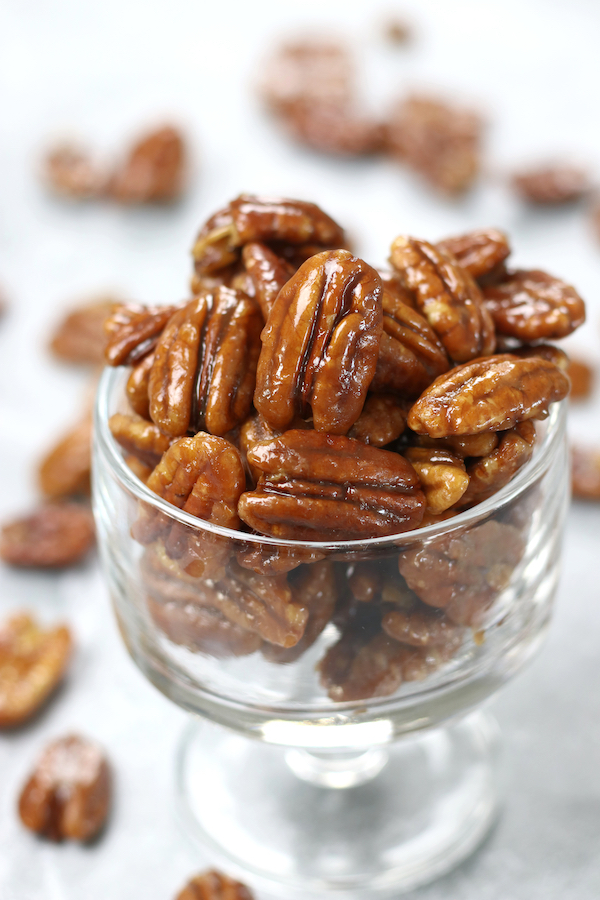 Caramelized Pecans made with butter and maple syrup in a small glass parfait.