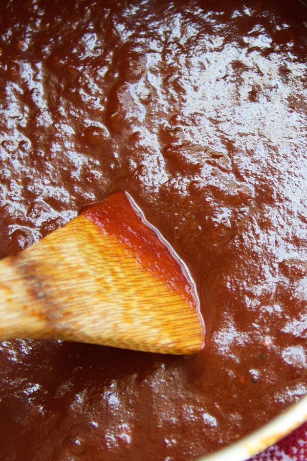 Homemade Barbecue Sauce being stirred by a wooden spoon.