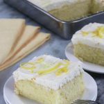 Lemon Cake with Cream Cheese Frosting served next to yellow cloth napkins.