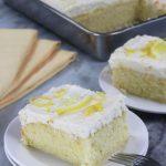 Two slices of Lemon Sheet Cake served on small white plates.