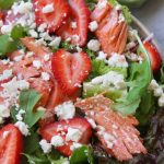 Overhead photo of Salmon Salad with Strawberries sitting next to a green napkin.