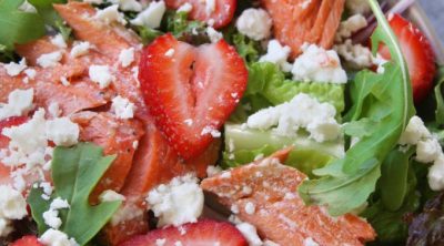 Overhead photo of Salmon Salad with Strawberries sitting next to a green napkin.