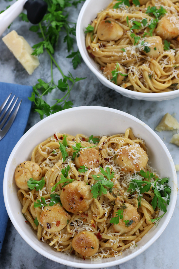 Two served bowls of a Scallops and Pasta recipe made with White Wine, garlic and lemon.