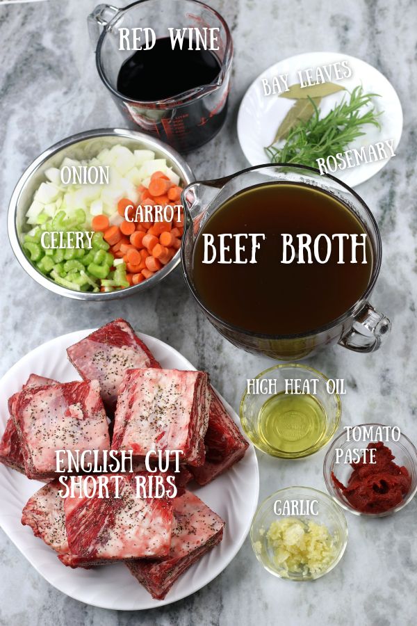 Overhead photo of Red Wine Braised Short Ribs ingredients on a white marble countertop.