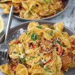 Creamy Cajun Pasta served on grey plates and garnished with a sprinkling of parsley.