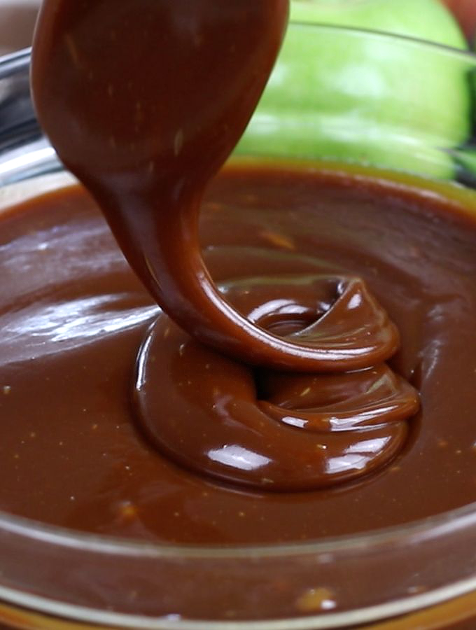 A spoon drizzling Dark Caramel Sauce.