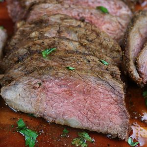 Incredibly juicy Dry Rubbed Tri-Tip sliced on a cutting board.