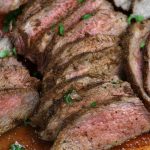 Oven Roasted Tri-Tip sliced on a wooden cutting board.