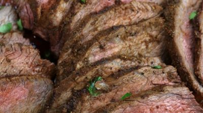 Oven Roasted Tri-Tip sliced on a wooden cutting board.