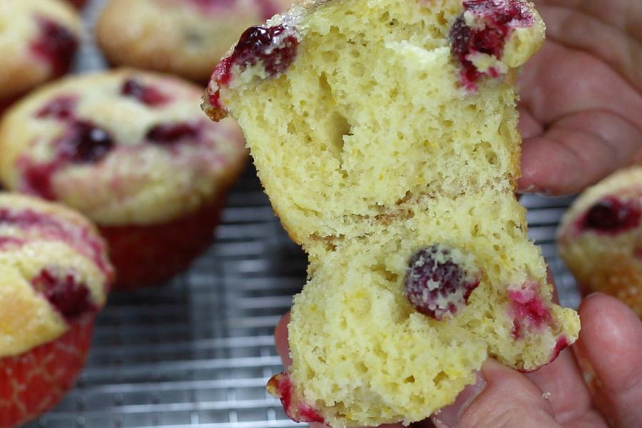 Up close photo of Cranberry and Orange Muffins with white lights in background.
