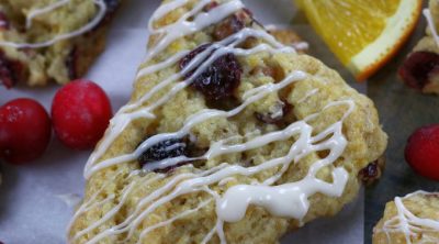 Orange Cranberry Scones surrounded by cranberries and orange slices.