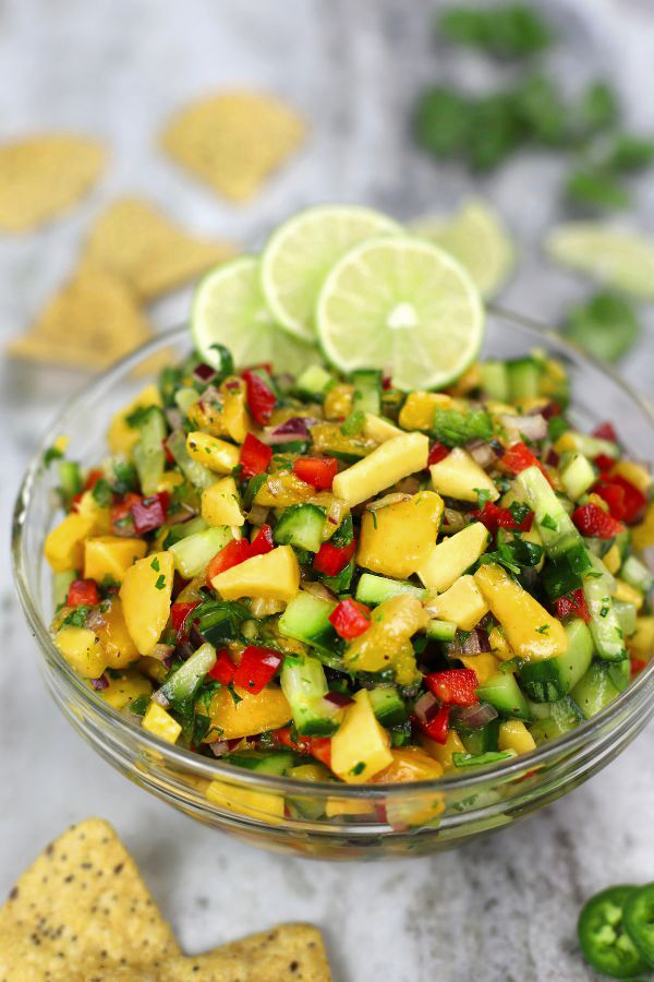 Cucumber and Mango Salsa in a large bowl garnished with 3 lime slices.