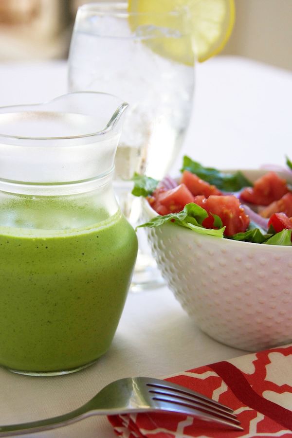 Cilantro Lime Salad Dressing in a salad dressing jar next to a bowl full of salad.