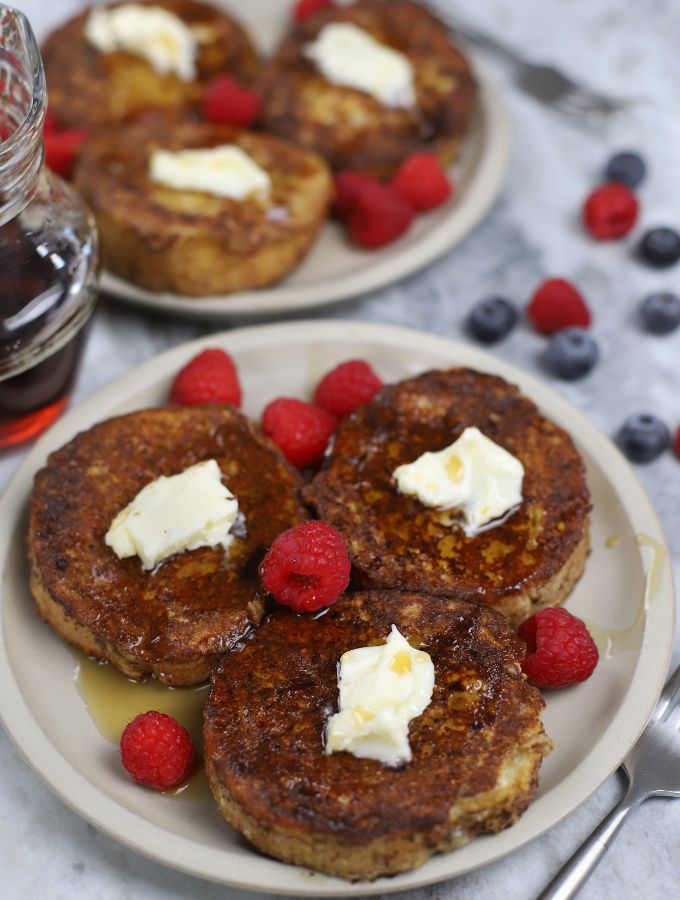 Three slices of Sourdough French Toast on a tan plate.