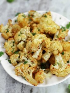 A white plate full of Roasted Cauliflower.