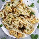 Overhead photo of Roasted Cauliflower drizzled with creamy Tahini Dressing.