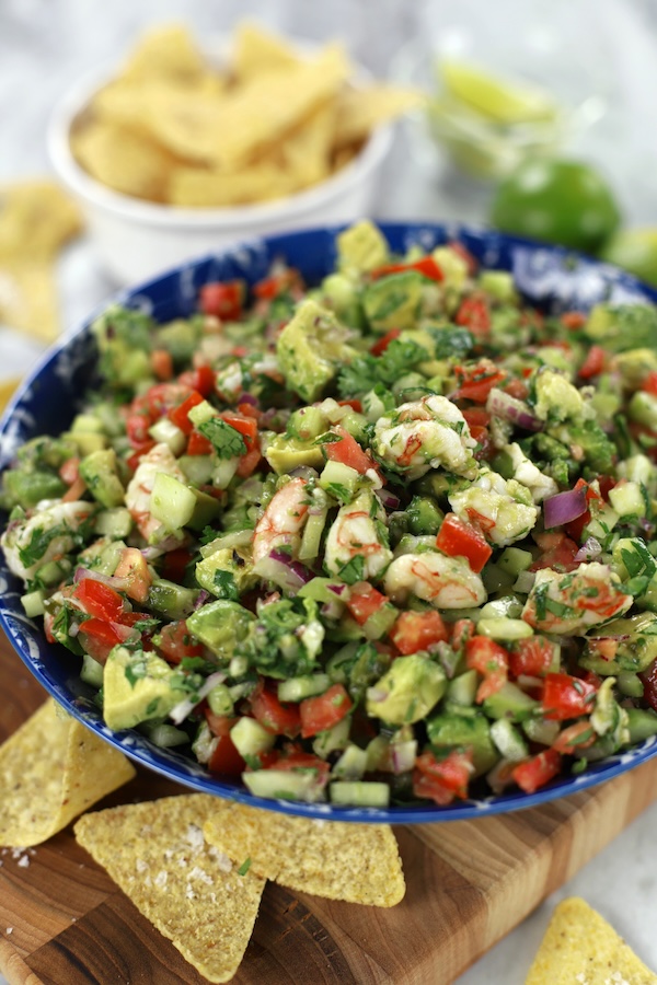 Easy Shrimp Ceviche in a blue bowl surrounded by chips and limes.