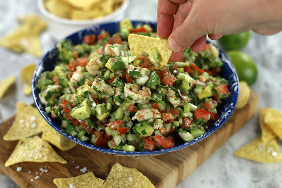 A chip halfway dipping into Easy Shrimp Ceviche.