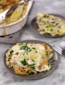 Creamy Scalloped Potatoes served on two small plates.