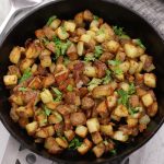 Overhead photo of Breakfast Potatoes that were made in the oven and a cast iron frying pan.