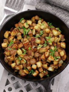 Oven Breakfast Potatoes in a cast iron frying pan sitting on a metal trivet.