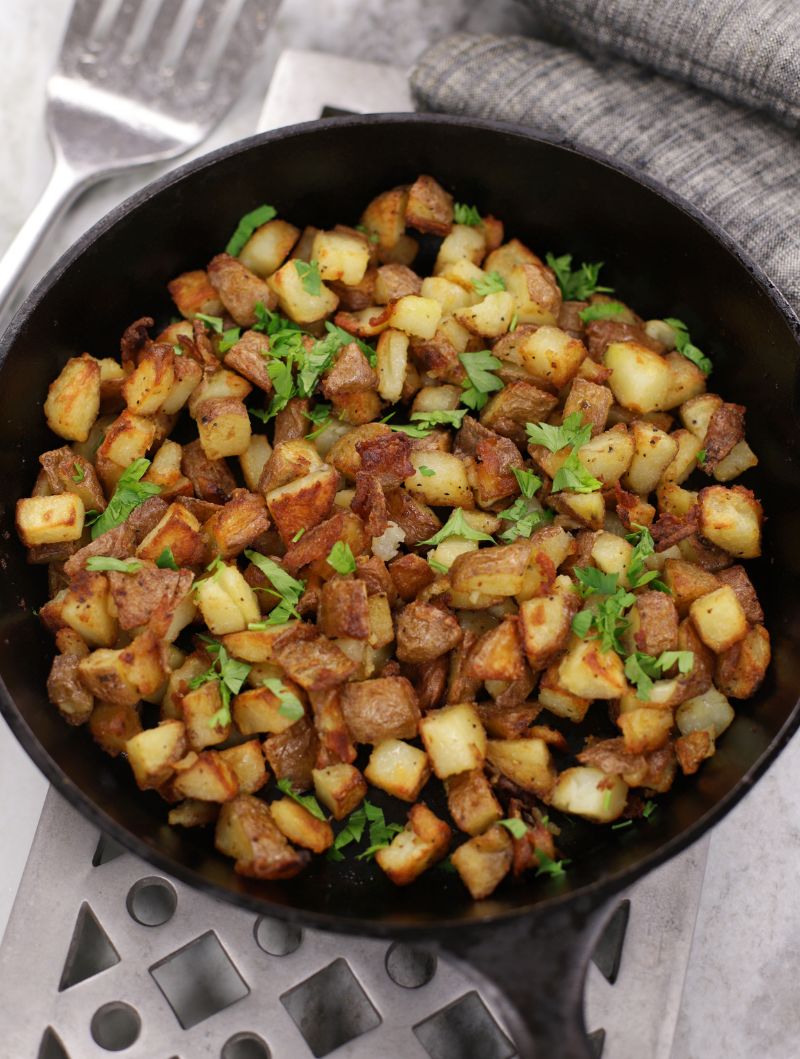Oven Breakfast Potatoes in a cast iron frying pan sitting on a metal trivet.