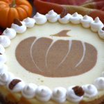 Overhead photo of a Pumpkin Cheesecake with Ginger Cookie Crust sitting next to a fall colored cloth napkin.