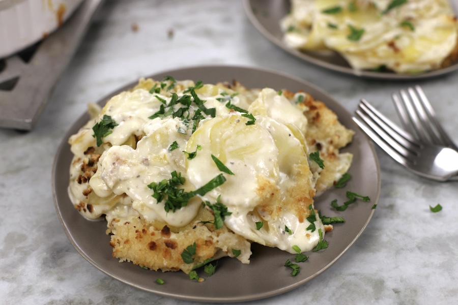 Best Au Gratin Scalloped Potatoes with extra creamy potato slices on a small plate.