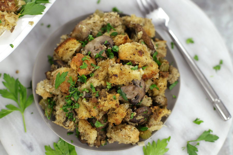 Overhead photo of a small plate of Sourdough Bread Dressing sitting on a white marble countertop.