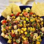 Black Bean Corn Salad Recipe served in a blue bowl sitting on a white marble countertop.