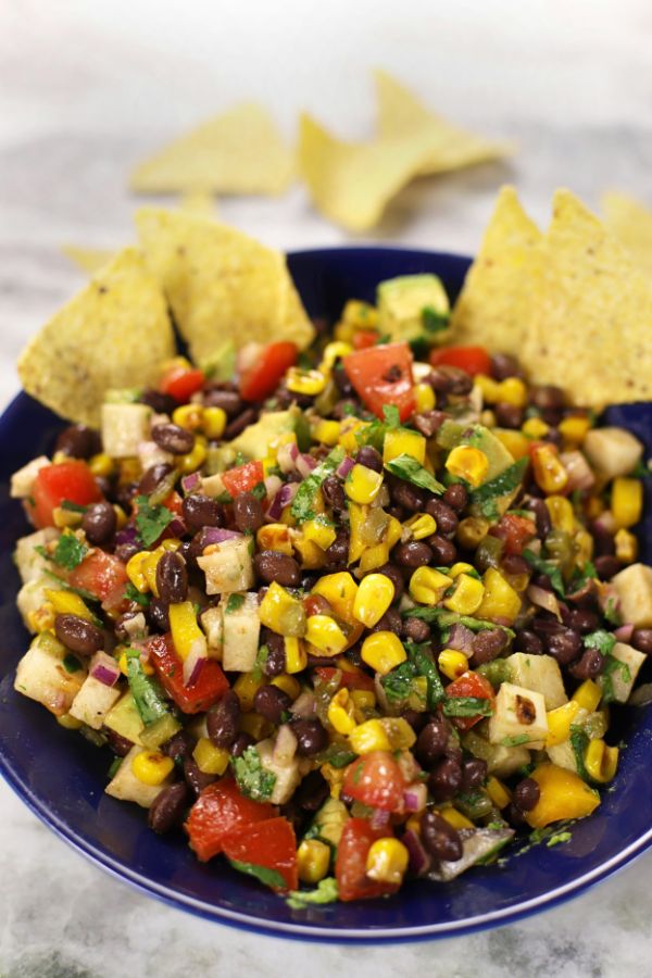 Black Bean Corn Salad Recipe served in a blue bowl sitting on a white marble countertop.