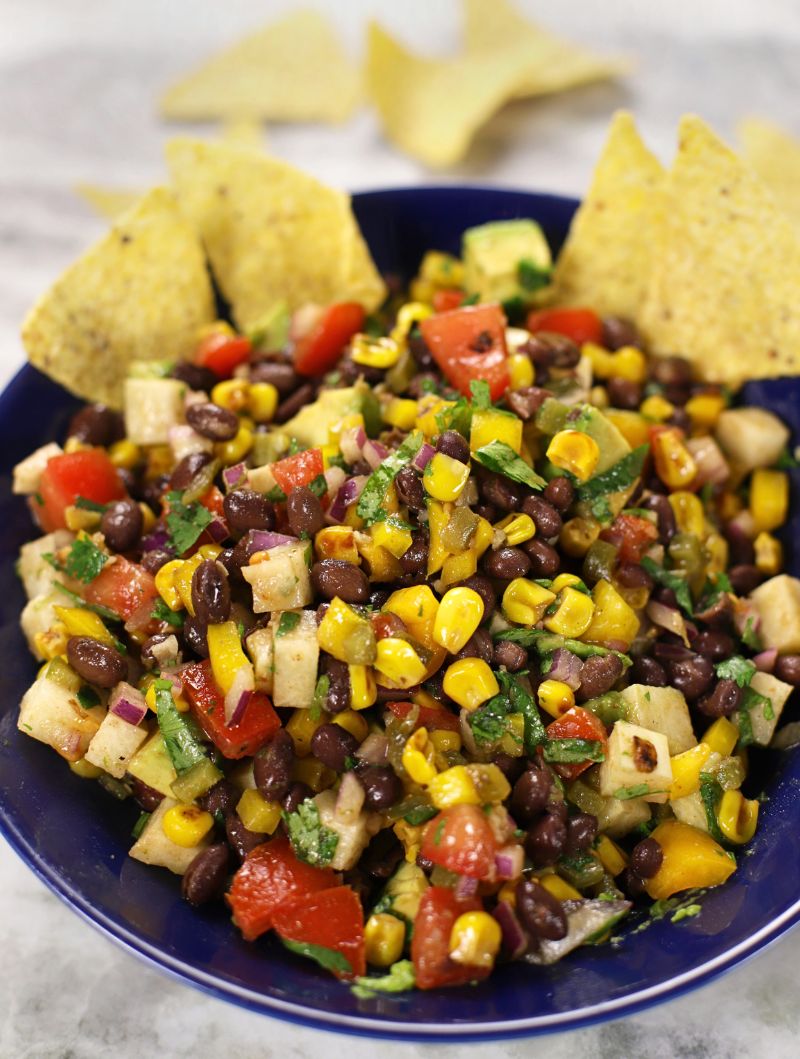 A blue bowl full of Black Bean and Corn Salad.