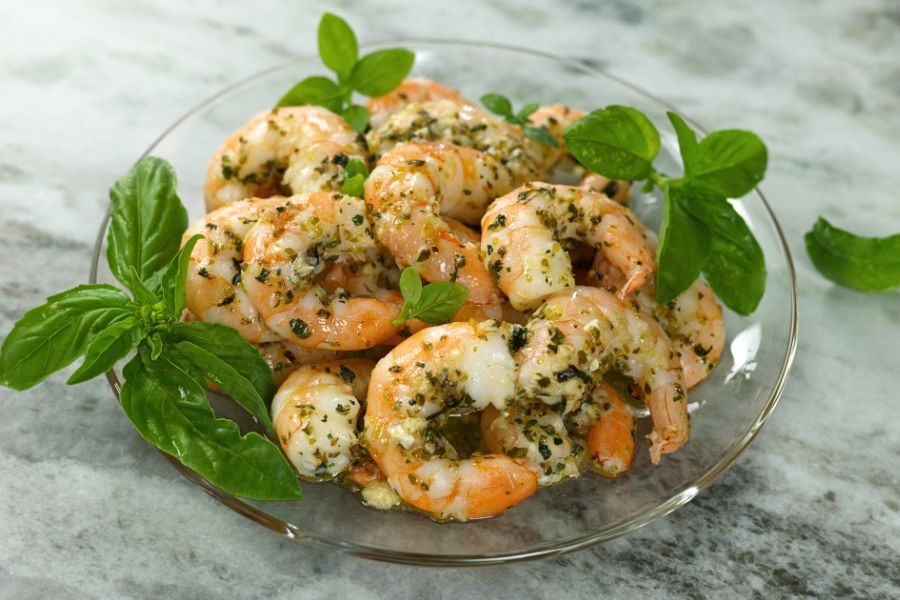 Juicy Roasted Shrimp with herbs and garlic on a glass plate.