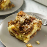 A slice of Sour Cream Coffee Cake on a light brown plate.
